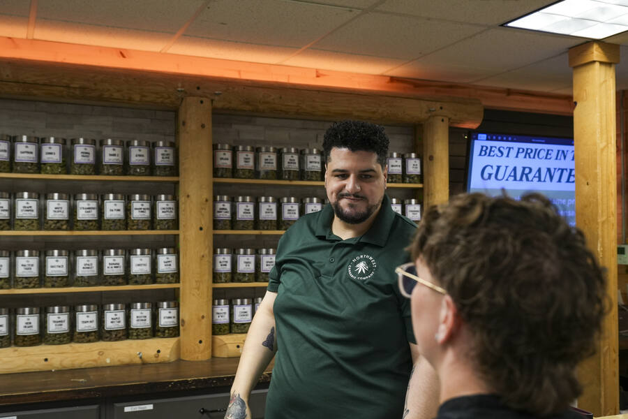 Northwest Cannabis Company budtender helping a customer at the counter